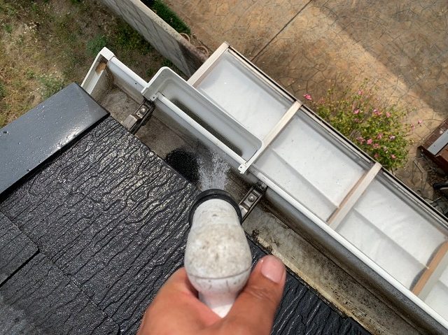 雨樋を流水で清掃する様子